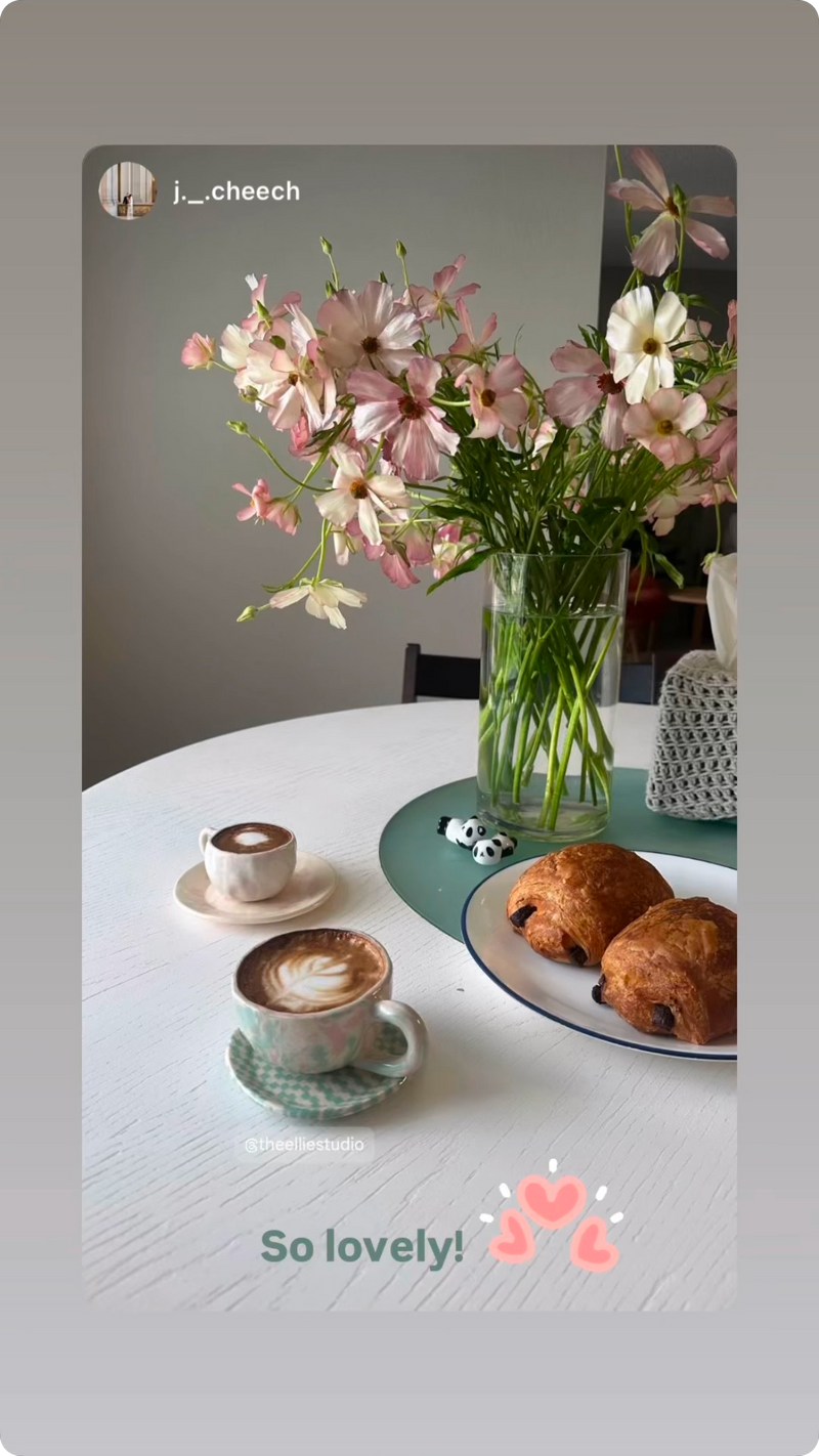cute pastel coffee mug and saucer sets on top of dinning table with croissant and flower vase lifestyle cozy lovely.
