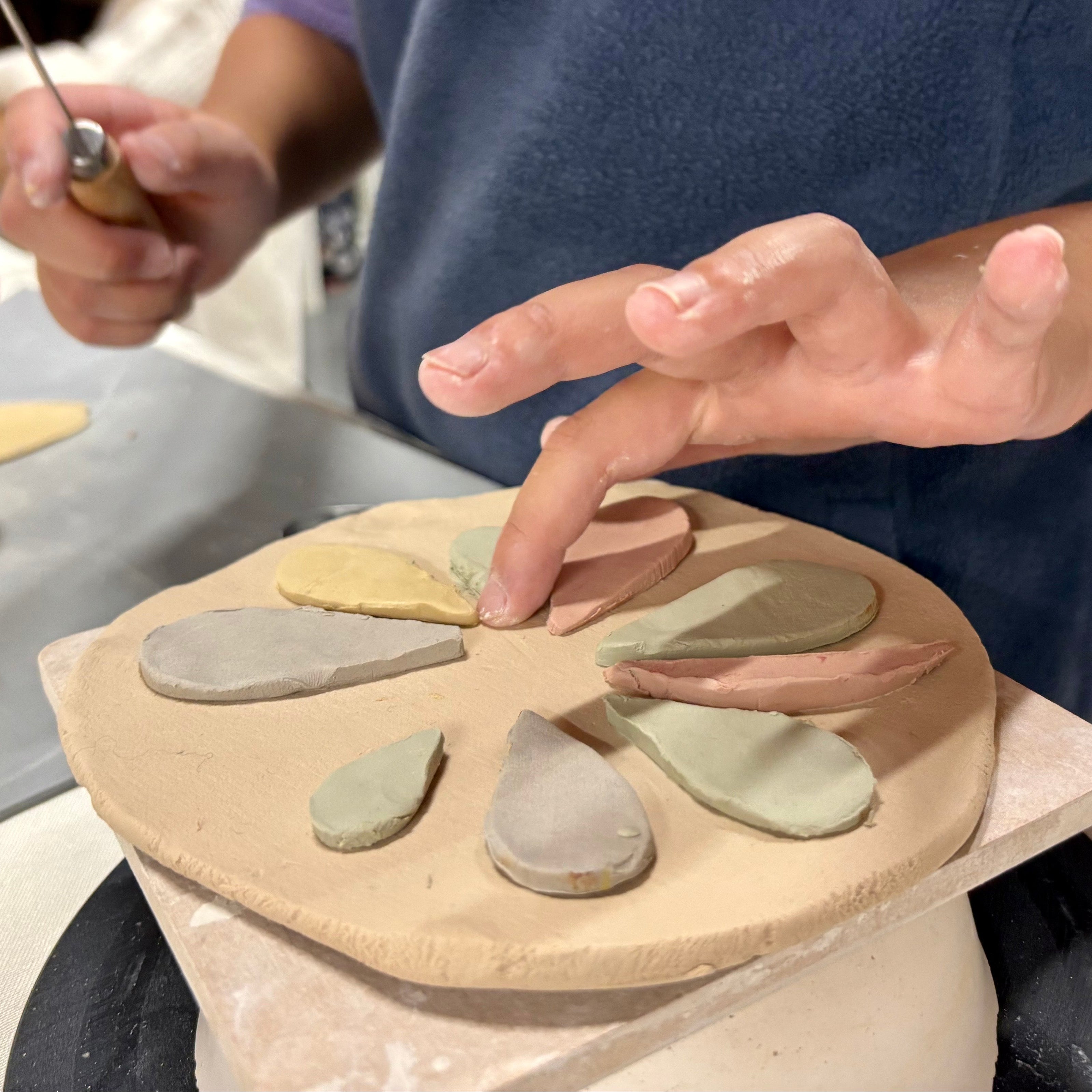 Person working with clay on a pottery in a home setting