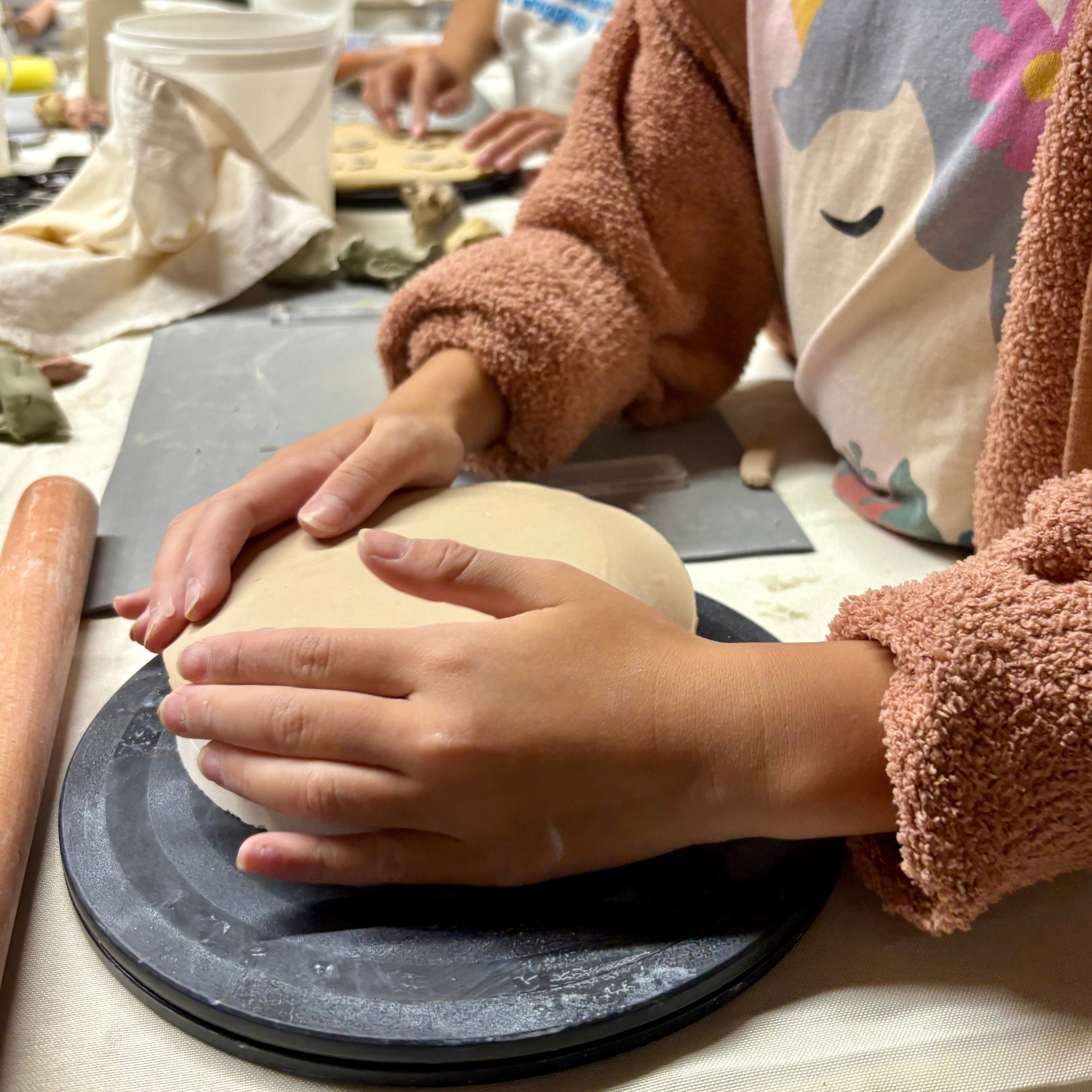Person working with clay putting clay on a mold slab building