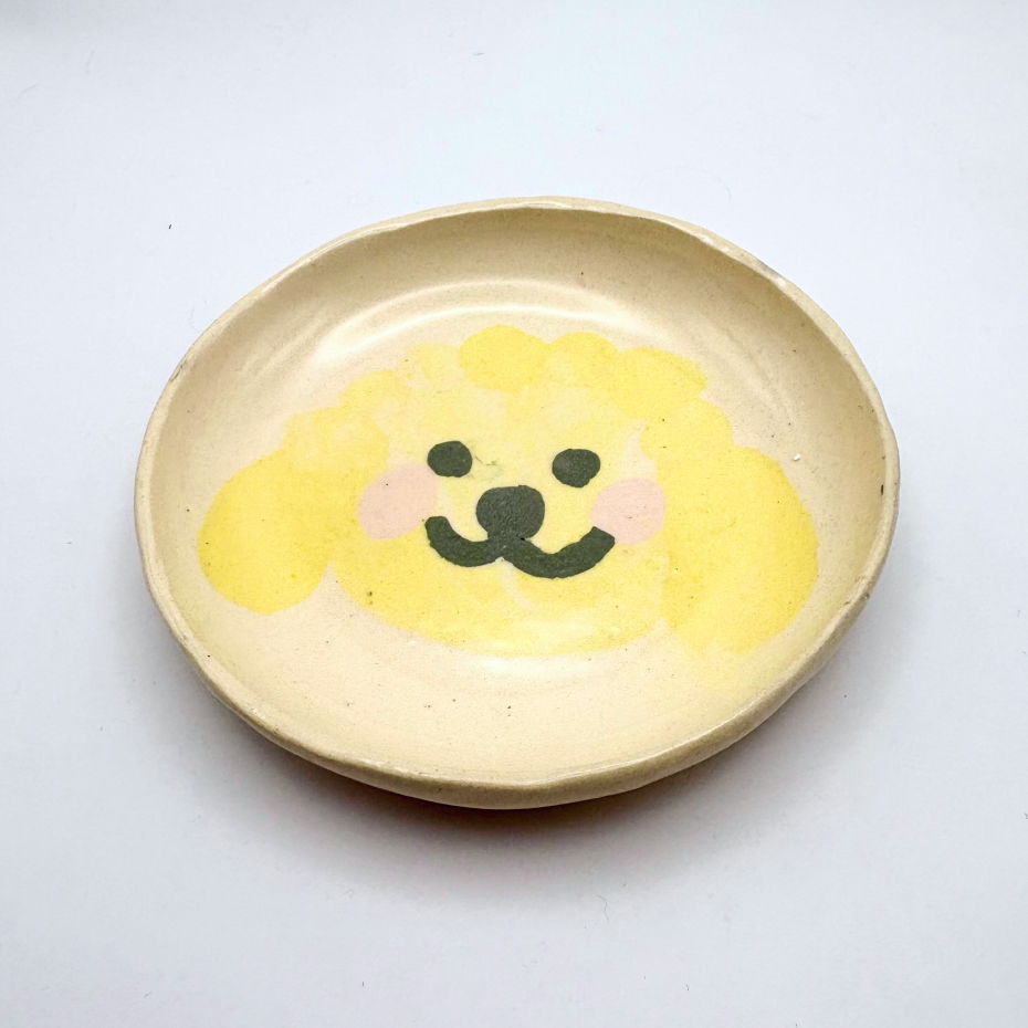 Handmade patterned ceramic plates created by students in a Nerikomi workshop. Cute yellow dog.